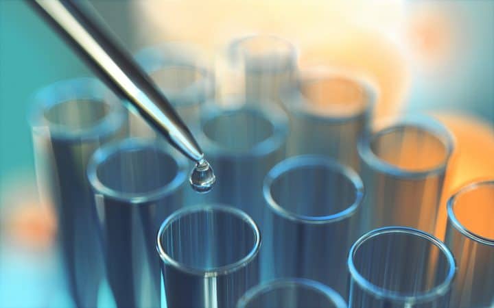 Photo d'une pipette devant des tubes à essais pour le traitement des eaux de process - Aquastrat, Conseil, Expertise et Stratégie